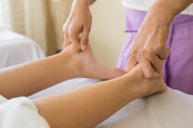 Close-up van vrouw die voetmassage doet bij kuuroord.