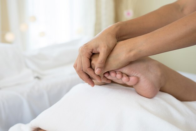 Close-up van vrouw die voetmassage doet bij kuuroord.