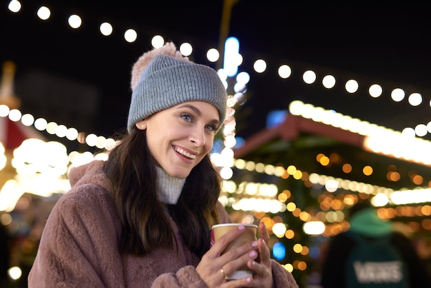 Close up van vrouw glühwein drinken op koude nacht