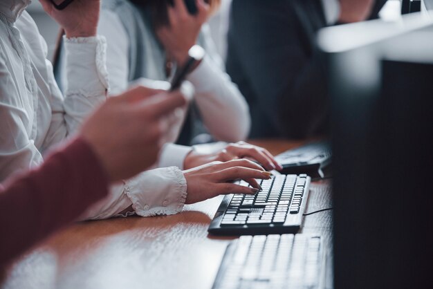 Close-up van vrouw handen typen op toetsenbord. Jonge mensen die in het callcenter werken. Er komen nieuwe deals aan