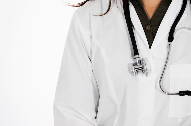 Close-up van vrouwelijke arts met stethoscoop rond haar die hals op witte achtergrond wordt geïsoleerd