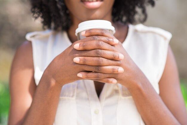 Close-up van vrouwelijke handen met een kopje koffie