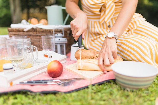 Close-up van vrouwen scherp brood met mes op picknick
