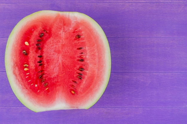 Close-up van watermeloen half op paarse achtergrond met kopie ruimte