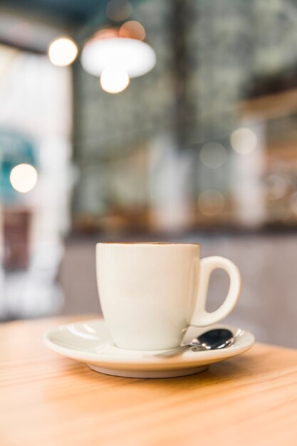 Close-up van witte koffiekop op houten lijst