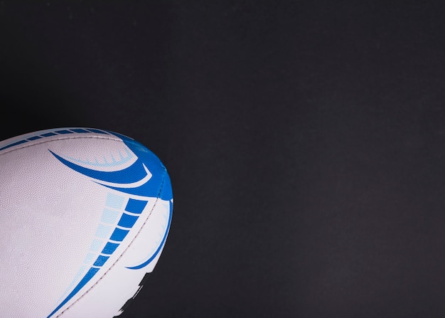 Gratis foto close-up van witte rugbybal op zwarte achtergrond
