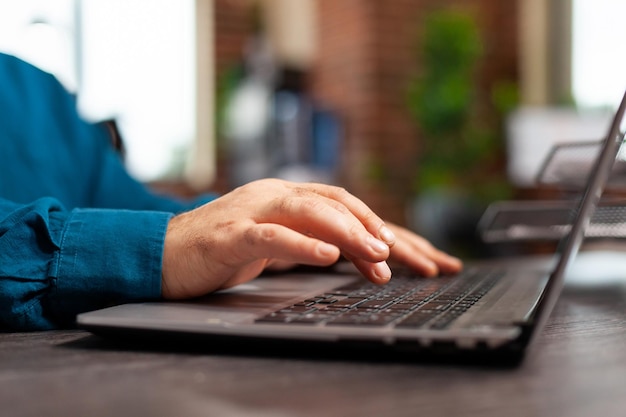 Close-up van zakenmanhand die beheersgrafieken analyseert die bedrijfsstrategie op laptoptoetsenbord typen die bij marketingproject werken. Uitvoerend manager die bedrijfsinvesteringen plant in startbureau