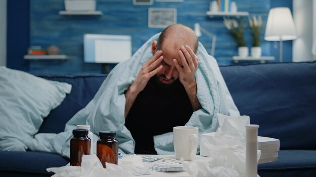 Close up van zieke volwassene met hoofdpijn die over de slapen wrijft