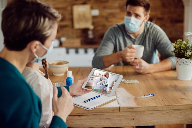 Gratis foto close-up van zwarte arts die videogesprek voert met een gezin tijdens een pandemie van het coronavirus