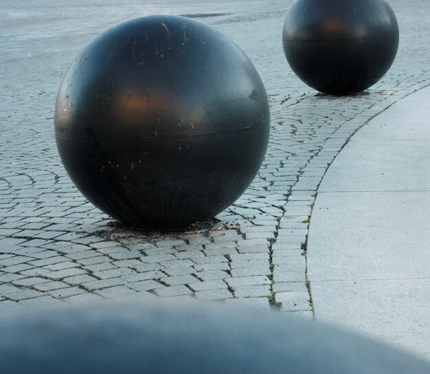 Close-up van zwarte ronde ballen op steenachtige grond