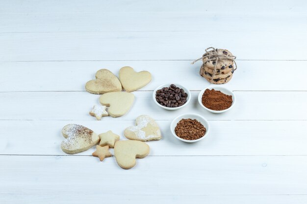 Close-up verschillende soorten koekjes met koffiebonen, instant koffie, cacao op witte houten plank achtergrond. horizontaal