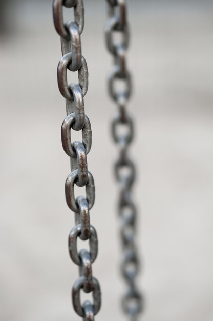 Close-up verticaal shot van een metalen ketting op wazig