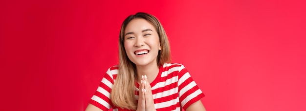 Gratis foto close-up vrolijk zorgeloos lachen schattig aziatisch meisje hand in hand bidden biddende vriend helpen een grapje smili