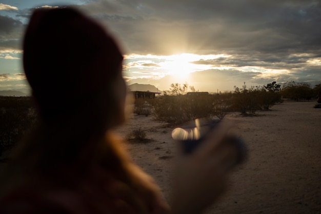 Gratis foto close-up vrouw met mok in amerikaanse woestijn