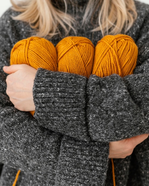 Gratis foto close-up vrouw met oranje breigaren