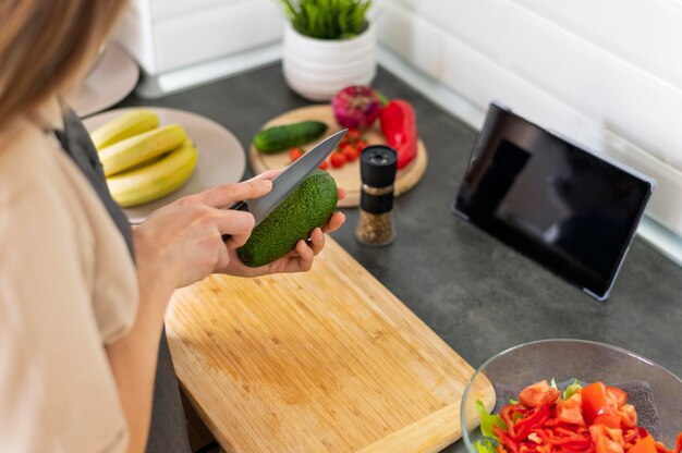 Close-up vrouw snijden komkommer