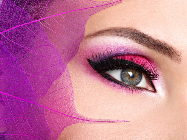 Close-up vrouwelijk oog met mooie mode helder roze make-up