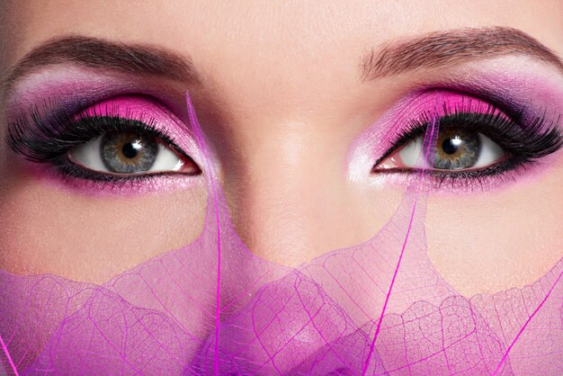 Close-up vrouwelijk oog met mooie mode helder roze make-up