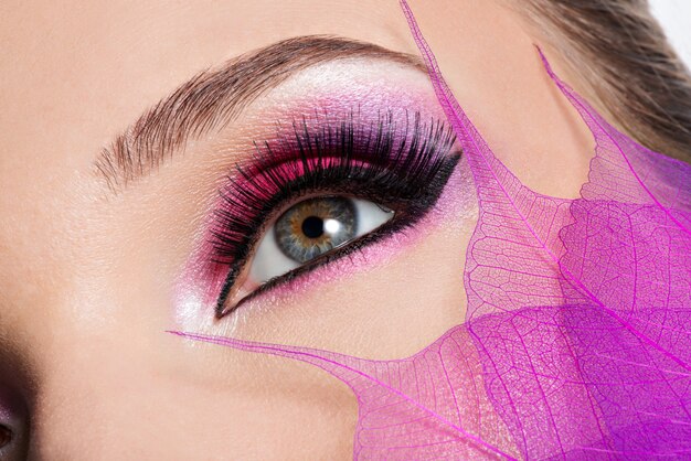 Close-up vrouwelijk oog met mooie mode helder roze make-up