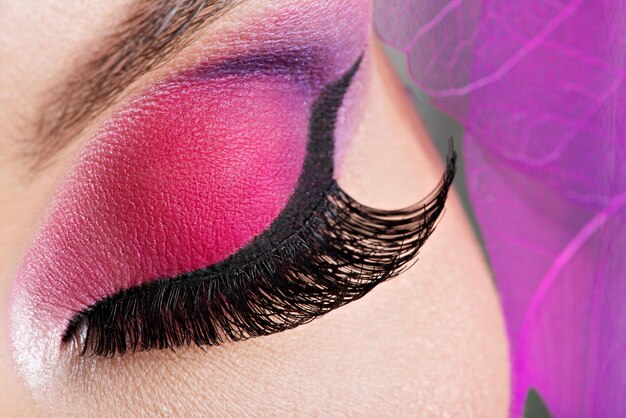 Close-up vrouwelijk oog met mooie mode helder roze make-up