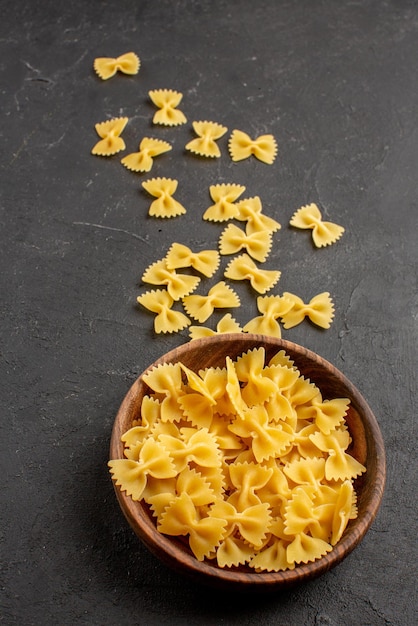 Close-up zijaanzicht pasta smakelijke pasta in houten kom op de donkere tafel