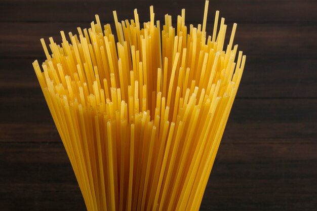 Close-up zijaanzicht rauwe spaghetti op een houten oppervlak
