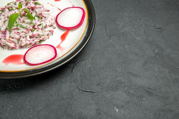 Close-up zijaanzicht smakelijk gerecht schotel van radijs op de witte plaat op de donkere tafel