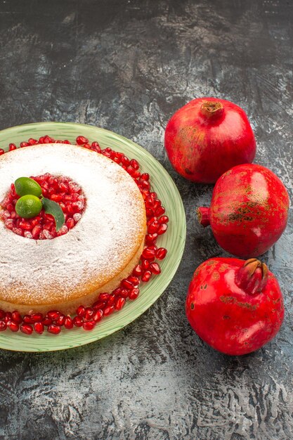 Close-up zijaanzicht zaden van granaatappels drie rode granaatappels en de smakelijke cake