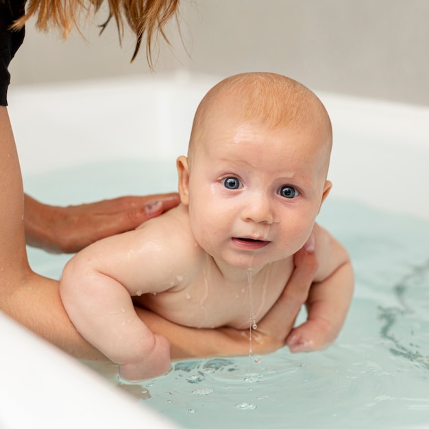 Close-upbaby met blauwe ogen in de badkuip