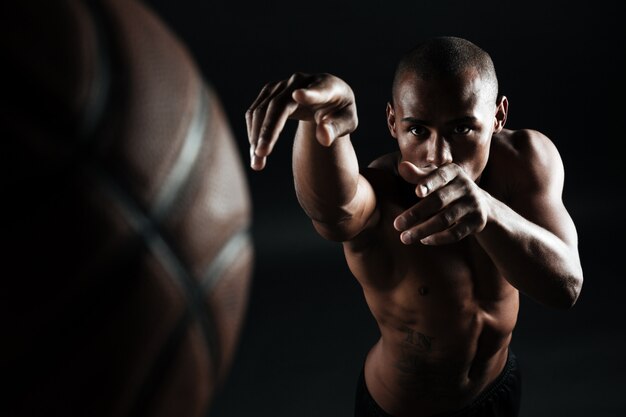 Close-upfoto van Afro-Amerikaanse basketbalspeler die bal werpt,