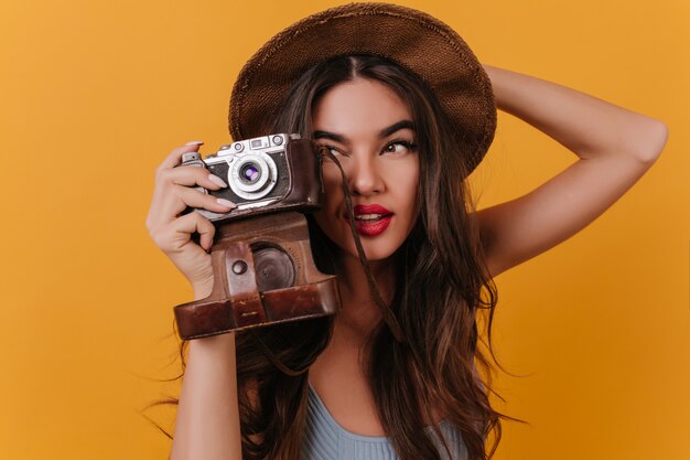 Close-upfoto van geconcentreerde vrouwelijke fotograaf met donker lang haar