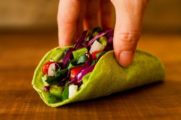 Close-uphand die vegetarische taco houden