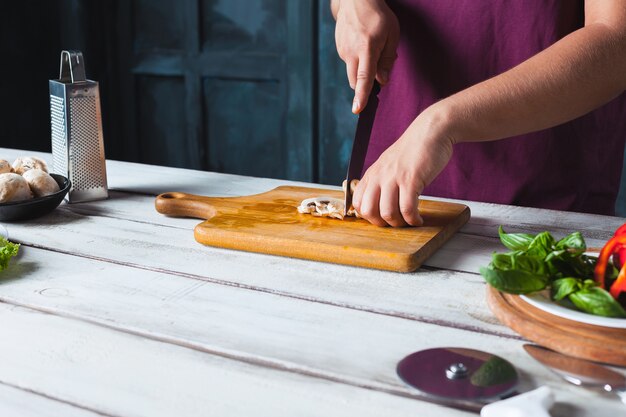 Close-uphand van chef-kokbakker die pizza maken bij keuken