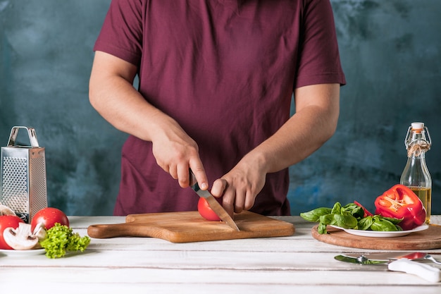 Close-uphand van chef-kokbakker die pizza maken bij keuken