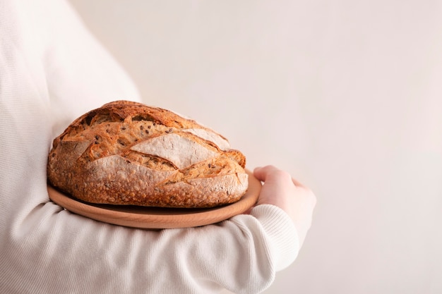 Close-uphanden die plaat met brood houden