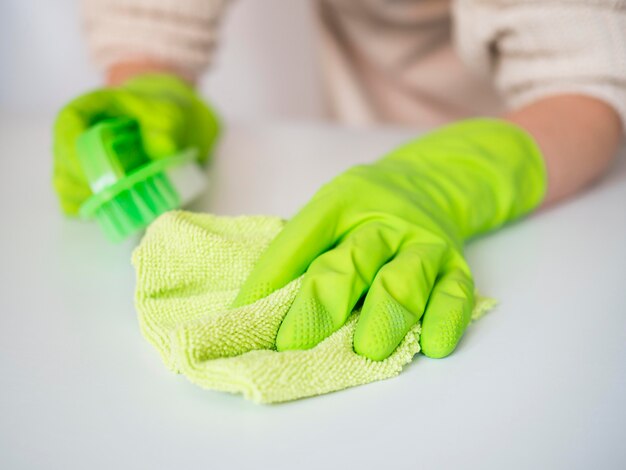 Close-uphanden met rubberhandschoenen die doek houden