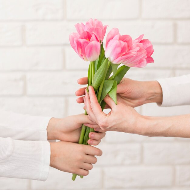 Close-upjongen die bloemen aanbieden aan moeder