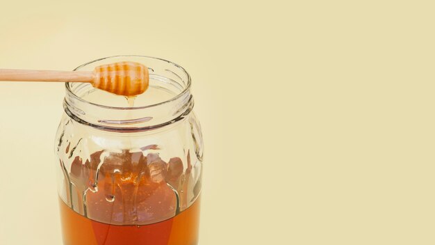 Close-upkruik met smakelijke honing wordt gevuld die