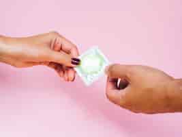 Gratis foto close-upman en vrouw die een groen condoom houden