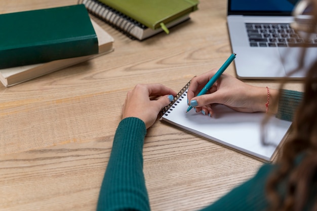 Close-upmeisje die op een notitieboekje schrijven