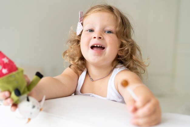 Close-upmeisje met lolly en stuk speelgoed