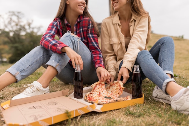 Close-upmeisjes die pizza eten
