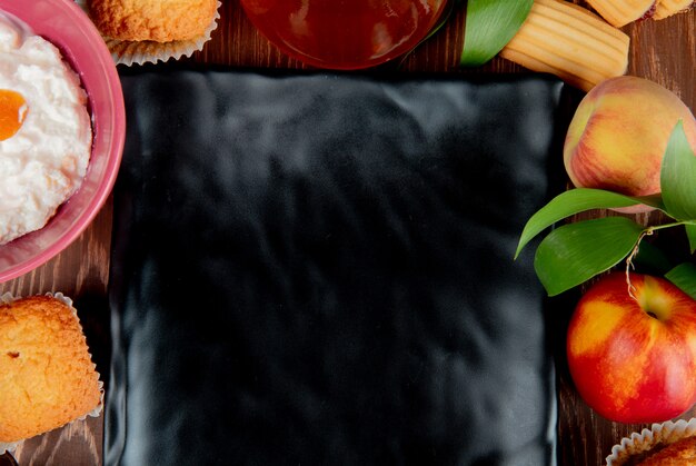 Close-upmening van de jam cupcake kaas van de perzikperzik perzik met plaat op centrum op houten lijst