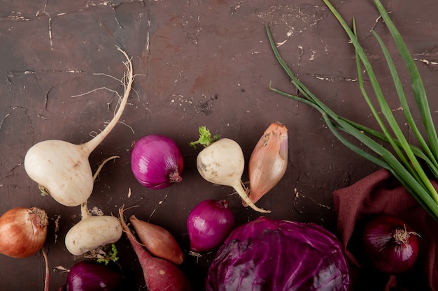 Gratis foto close-upmening van groenten als ui van de radijsui de purpere kool op kastanjebruine achtergrond met exemplaarruimte