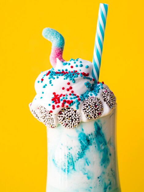 Close-upmening van heerlijke milkshake met gele achtergrond