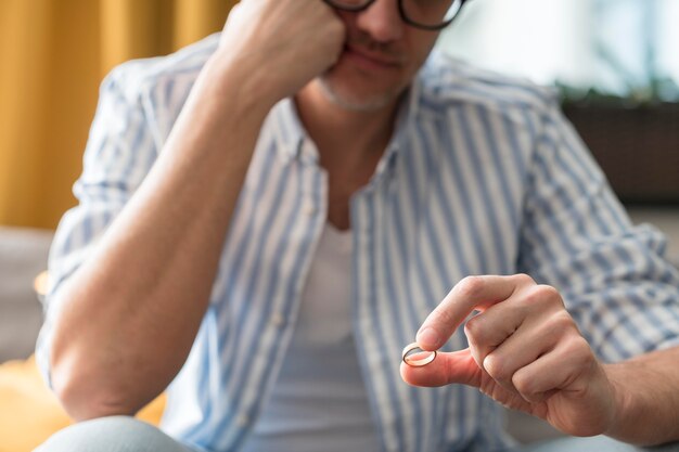 Close-upmens die zijn trouwring houden