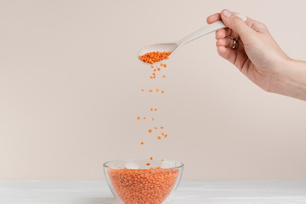 Close-upmens met lepel en kom zaden