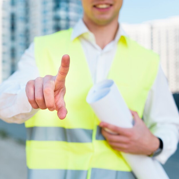 Close-upmens met veiligheidsvest en plannen