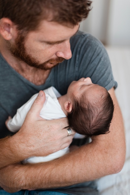 Gratis foto close-upouder die zijn baby houdt