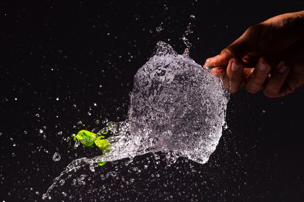 Close-uppersoon die een waterballon knalt